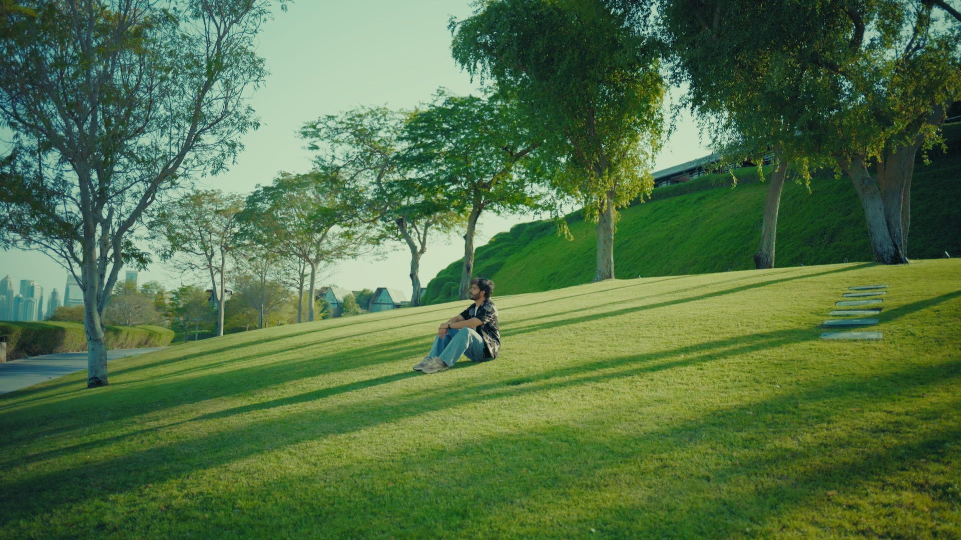The same frame graded: green grass, warm late sun through the trees and natural skin.